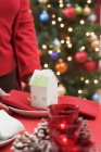 Woman holding plate on Christmas table — Stock Photo