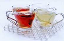 Glass cups of black and white tea — Stock Photo