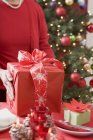 Mujer poniendo paquete de Navidad - foto de stock