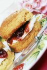 Scone filled with jam and cream — Stock Photo
