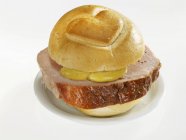 Closeup view of Leberkse meatloaf in bread roll with heart — Stock Photo