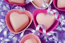 Chocolates en forma de corazón en cubiertas de pastel - foto de stock