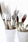 Closeup view of silver cutlery in white beakers — Stock Photo