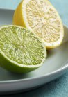 Halved lemon and lime on plate — Stock Photo
