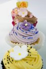 Fila de cupcakes de colores decorados con flores - foto de stock
