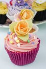 Cupcakes decorated with orange rose flowers — Stock Photo