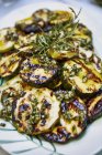 Fette di zucchina grigliate su piatto bianco e fondo sfocato — Foto stock