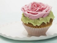 Cupcake decorated with sugar rose — Stock Photo