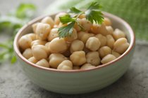 A green  bowl of chickpeas over table — Stock Photo