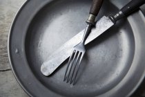 Closeup view of a tin plate with silver cutlery — Stock Photo