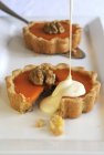 Vanilla sauce being poured over pumpkin pie — Stock Photo