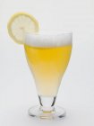 Copa de shandy con rodaja de limón - foto de stock