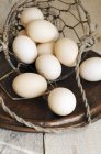 Huevos que caen de cesta de alambre - foto de stock