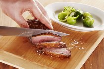 Hands slicing Roasted duck breast — Stock Photo