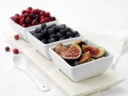 Fresh figs and berries in bowls — Stock Photo