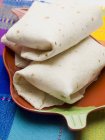 Vista de close-up de parcelas Tortilla em prato em pano colorido — Fotografia de Stock