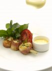 Closeup view of scallops in bacon on skewer with tomato half, herbs and sauce — Stock Photo