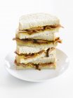 Стек бутербродів з беконом та цибулею на білій тарілці — стокове фото