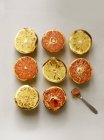 Top view of grilled grapefruits and spoon on white surface — Stock Photo