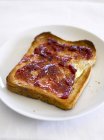 Closeup view of buttered toast with marmalade on white plate — Stock Photo