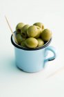 Зелені оливки в кухоль — стокове фото
