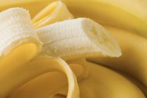Plátanos frescos medio pelados - foto de stock