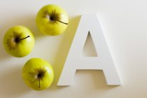 Manzanas verdes y letra A - foto de stock