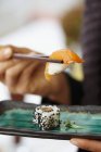 Persona comiendo sushi de salmón nigiri - foto de stock