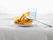 Fischstäbchen mit Zitrone auf Teller — Stockfoto