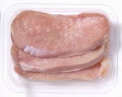 Raw Turkey escalopes in plastic container — Stock Photo