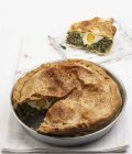 Torta Pasqualina spinach and egg pie in platter over towel — Stock Photo
