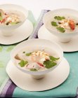 Повышенный вид на креветочный суп с кориандром в мисках — стоковое фото