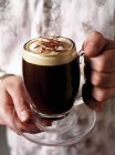 Руки держат ирландский кофе — стоковое фото