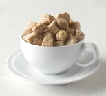 Brown sugar cubes in cup — Stock Photo