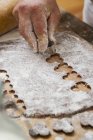 Konditor schneidet Kekse aus — Stockfoto