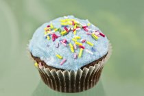 Cupcake decorated with blue buttercream icing — Stock Photo