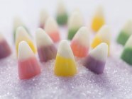 Closeup view of candy corn on purple granulated sugar — Stock Photo