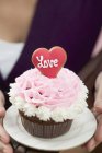 Female hand holding cupcake — Stock Photo
