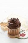 Cupcake con glaseado de chocolate y espolvoreos - foto de stock