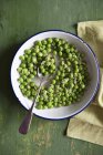 Peas with parmesan in bowl — Stock Photo