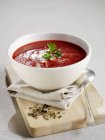 Borscht with sour cream on white dish over wooden desk with spoon — Stock Photo