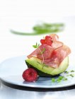 Closeup view of avocado wedge with salami and berries — Stock Photo