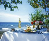 Vista diurna de una mesa puesta para una comida junto al mar en Bali - foto de stock