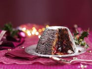 Christmas pudding, with a slice removed — Stock Photo