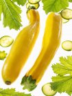 Yellow courgettes with slices and leaves — Stock Photo