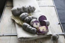 Whole and halved Violet truffle potatoes — Stock Photo