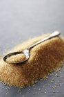 Teaspoon on pile of brown sugar — Stock Photo