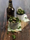 Grünkohl mit Mandelsplittern und einer Flasche Bier auf Holzoberfläche — Stockfoto