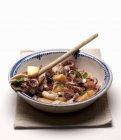 Octopus with potatoes and mint on plate with wooden spoon — Stock Photo