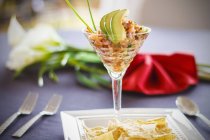 Seafood ceviche with avocado in glass over table — Stock Photo